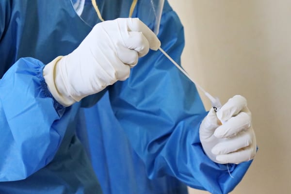 A laboratory worker takes a Covid-19 swab test