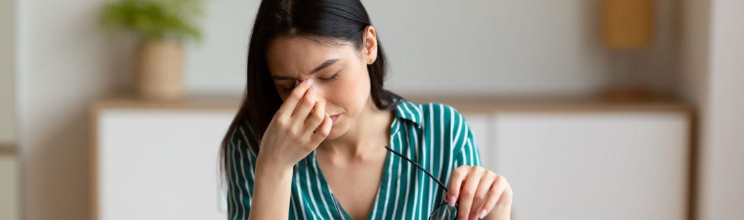 woman having eyes fatigue massaging nosebridge work