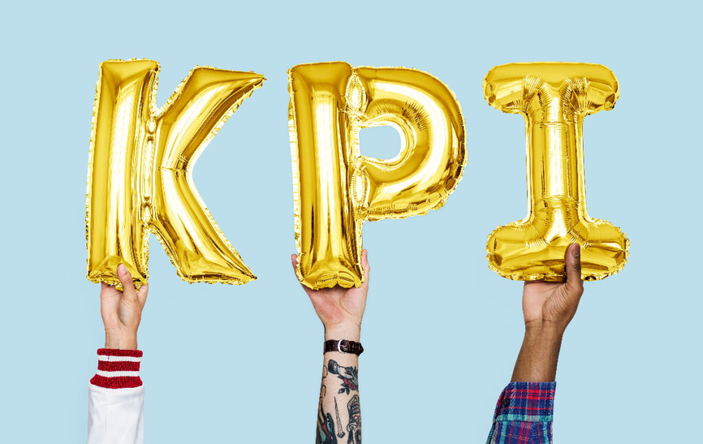 Hands holding up KPI letter balloons