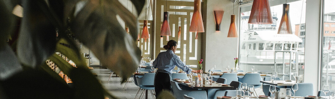 A waiter setting up tables in a restaurant