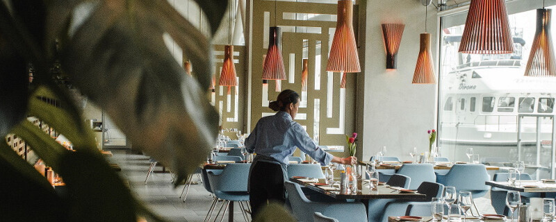 A waiter setting up tables in a restaurant